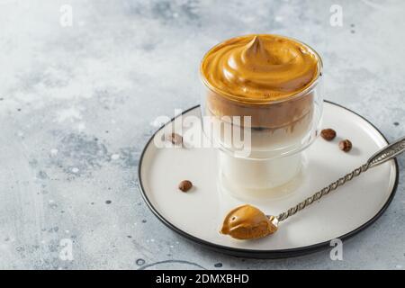 Caffè Dalgona. Bevanda fredda di tendenza cremosa e soffice montata con schiuma di caffè e latte. Drink alla moda durante il Covid-19 città chiusa e auto quarantena Foto Stock