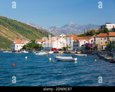 Lepetane, Tivat, Montenegro. Case sul lungomare che si affacciano sullo stretto di Verige, punto più stretto della baia di Cattaro. Foto Stock