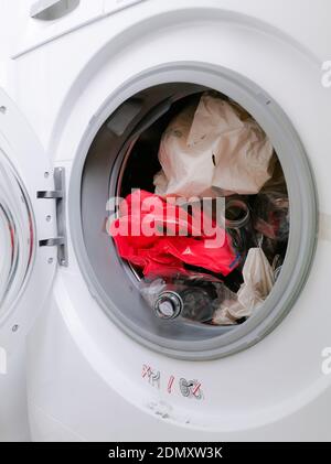 Washing machine filled with plastic waste representing micro plastic waste pollution during laundry Stock Photo