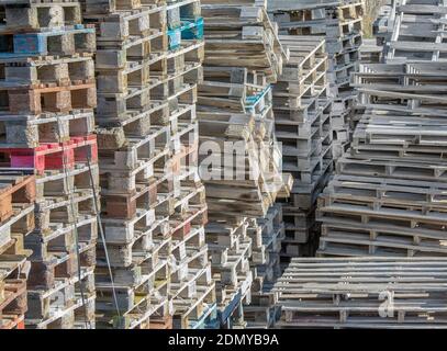 Crate industriali in legno. Isolato. Accatastato su scatole di legno usate e pallet per frutta e verdura in deposito. Immagine stock Foto Stock