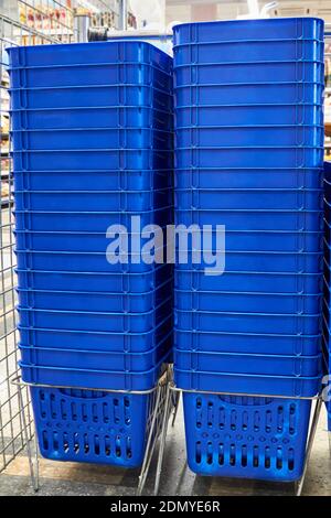Pile di cestini di plastica blu in un supermercato Foto Stock