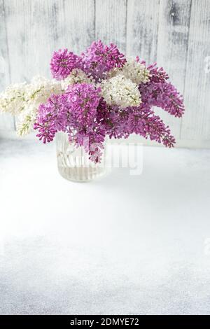 Bouquet di lilla in un vaso di vetro di fronte Parete con spazio per il testo - immagine Foto Stock
