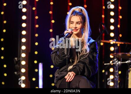 Halle, Germania. 16 Dic 2020. Ilira, cantante, suona durante il programma radiofonico 'amici del 2020' della stazione MDR Sputnik. Lo spettacolo, un mix di talk show e musica dal vivo, era già il quarto del suo genere. La stazione trasmette l'evento in diretta sulla radio e un flusso video sulla rete. Credit: Jan Woitas/dpa-Zentralbild/dpa/Alamy Live News Foto Stock