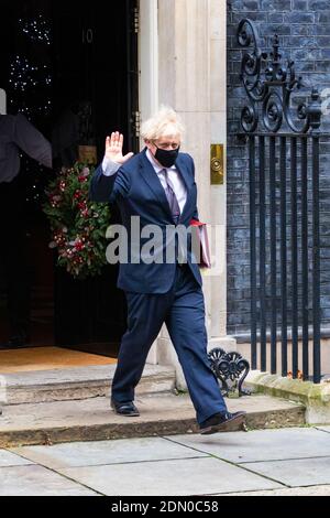 Il primo ministro Boris Johnson lascia il numero 10 Downing Street ondeggiante, corona di Natale sulla porta d'ingresso, Westminster, Londra, regno unito Foto Stock
