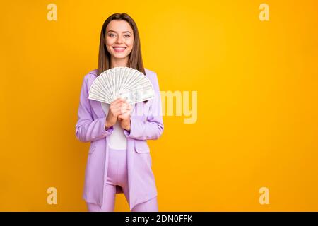 Ritratto di lei bella-aspetto attraente allegra allegra allegria felice ragazza ricca riuscita che tiene nelle mani contanti del ventilatore isolato sopra brillante e brillante Foto Stock