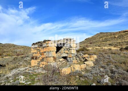 Capanna di pastori in pietra a secco su strada di campagna. Foto Stock