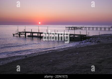 Pier silhouette on the beach at sunrise pink purple orange red skyline and background colors, comfortable holiday concept, in Antalya Turkey. Stock Photo