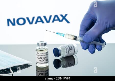 Morgantown, WV - 16 dicembre 2020: Bottiglia piccola di vaccino del coronavirus con siringa sullo sfondo del logo Novavax Foto Stock