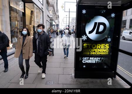 Con la fine del blocco nazionale e l'inizio del nuovo sistema a tre livelli di restrizioni al coronavirus locale, gli acquirenti si dirigono verso Oxford Street per recuperare i negozi non essenziali, in quanto i negozi non essenziali possono riaprire il 2 dicembre 2020 a Londra, Regno Unito. Molti acquirenti indossano maschere per il viso fuori strada come precauzione, in quanto ci sono così tante persone intorno. Foto Stock