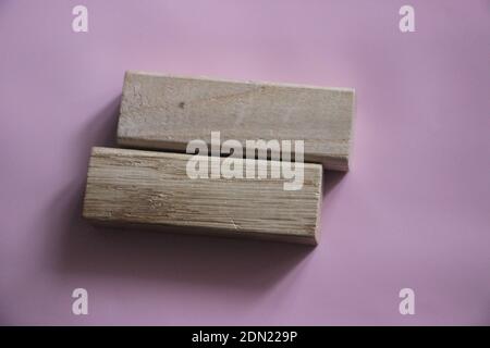 Due blocchi di legno che formano lo stesso segno su sfondo rosa tenue e lilla. Concept di tolleranza, uguaglianza e diversità, concetto di parità retributiva maschile e femminile. Foto Stock