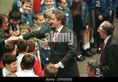 Il primo ministro britannico Tony Blair è accolto dai bambini delle scuole primarie locali quando arriva al parlamento scozzese sulla Mound a Edimburgo dove si è rivolto agli MSP al parlamento per la prima volta da quando il governo è stato devoluto in Scozia. L'Assemblea Generale ha ospitato il parlamento Scozzese dopo l'apertura il 1 luglio 1999 fino al completamento dell'edificio appositamente costruito a Holyrood nel 2004. Il nuovo parlamento ha conferito agli scozzesi, per la prima volta dal 1707, poteri limitati e devoluti dal governo britannico di Londra. Foto Stock