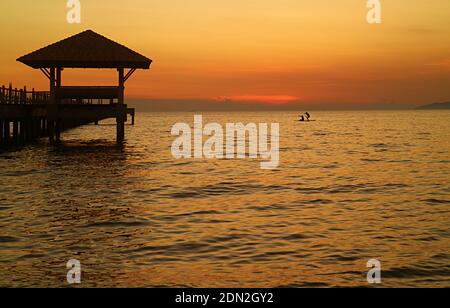 Silhouette di coppia di stand up paddle boarder contro bello cielo tramonto Foto Stock