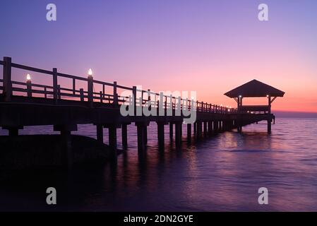 Silhouette di molo in legno con padiglione al tramonto Foto Stock