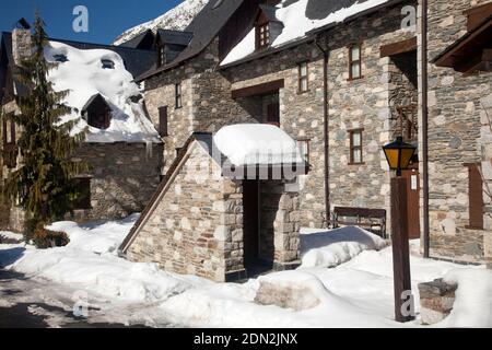 Vista orizzontale di una casa e di una cantina ingresso coperto di neve dopo una tempesta, Casarilh, Vall d’Aran, Lleida, Catalogna, Spagna Foto Stock
