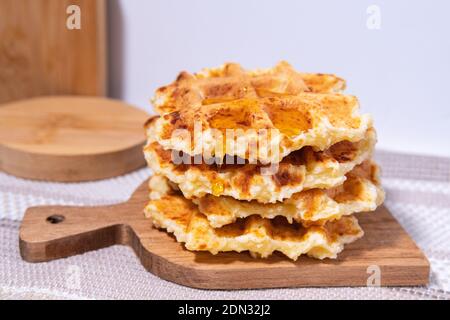 Miele che si versa su una cialda fresca. Cibo ecologico per colazione. Dolce confezione. Messa a fuoco selettiva Foto Stock