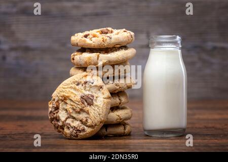 Biscotti al cioccolato e una piccola bottiglia di latte Foto Stock