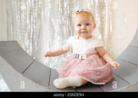 Funny femmina neonata con bella maglia rosa cappuccio su sfondo bianco.  Happy Baby girl con una bella maglia cappuccio colorato su coltre bianca.  Usura del neonato Foto stock - Alamy