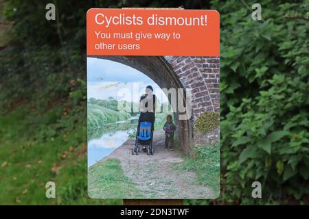 Un segno da un ponte che dice ai ciclisti di cedere il posto ai pedoni e ad altri utenti di alzaia sul Canal Grand Western a Sampford Peverell in Devon. Foto Stock