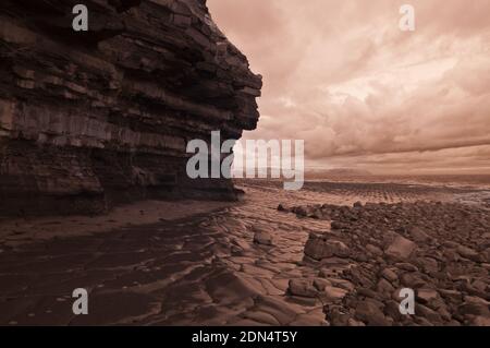 Foto infrarossa scattata a bassa marea del litorale roccioso del Jurassic sotto le scogliere a Kilve Beach, Somerset, Inghilterra, Regno Unito Foto Stock