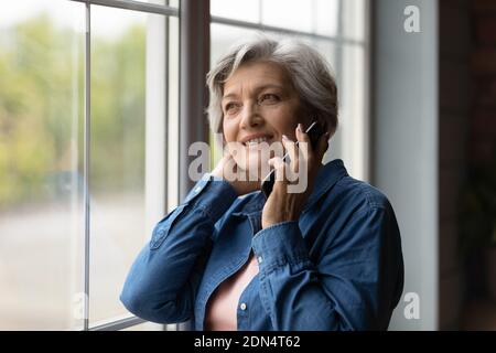 Felice metà anni 50 donna che parla sul telefono cellulare. Foto Stock