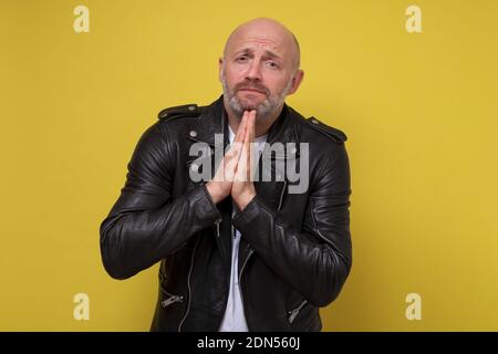 Disperato uomo maturo che mostra mani aggrappate, chiedendo aiuto o scusa. Vi prego di perdonarmi il concetto Foto Stock
