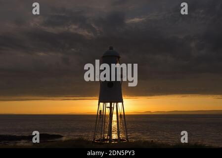 Un'immagine al tramonto con il faro di Black Nore che si affaccia sul canale di Bristol sulla costa vicino Portishead, Somerset, Inghilterra, Regno Unito. Foto Stock