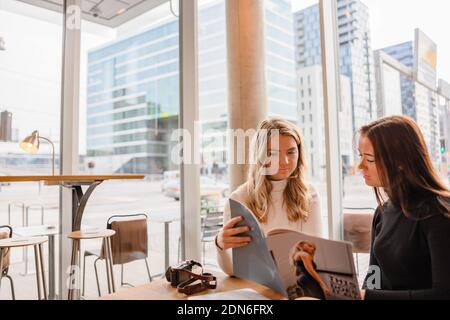 I giovani professionisti del blogger discutono sopra la pubblicazione nel caffè Foto Stock