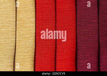 Design degli interni esempio di swaps di tessuti a tenda testurizzati di diverse sfumature di giallo oro, rosso e viola Bordeaux colori per la decorazione, confronto Foto Stock