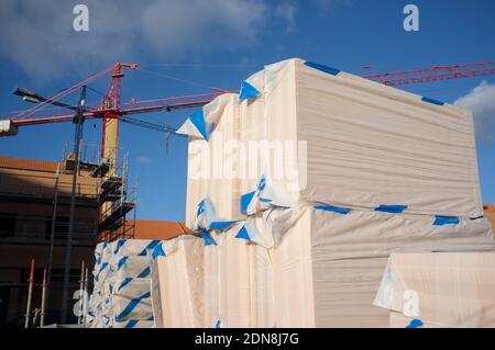 Extruded polystyrene foam packs at construction site. Cranes at bottom Stock Photo