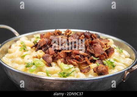 Ciotola di maccheroni e formaggio con un mucchio generoso di punte di pancetta per il sapore sulla parte superiore. Foto Stock