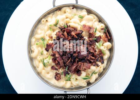 Vista dall'alto della ciotola di maccheroni e formaggio con un mucchio generoso di bacon per il sapore sulla parte superiore. Foto Stock