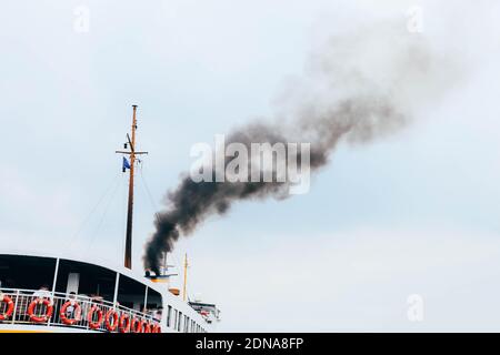 Spedire l'aria inquinante con fumo tossico su fondo blu del cielo. Concetto di problema di salute pubblica nelle aree popolate Foto Stock