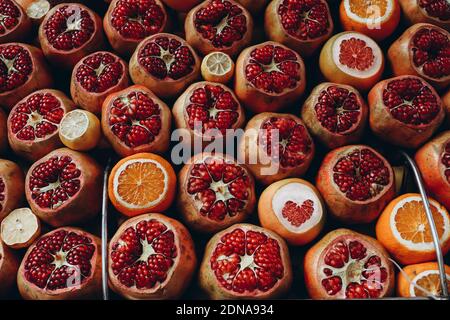 Vendita di melograni succosi maturi, arance in un mercato di strada. Vetrina aperta del mercato agricolo Foto Stock