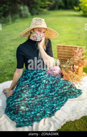 Donna che indossa una maschera di coronavirus che copre durante la pandemia di Covid-19 in un tiretto editoriale di moda Foto Stock