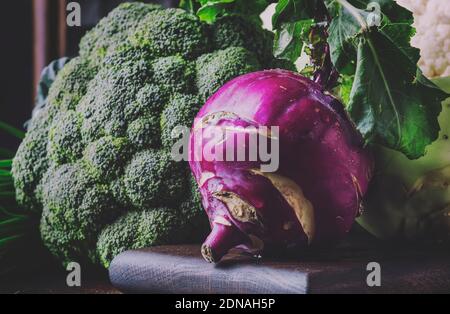 Diversi tipi di cavolo come cavolo bianco, cavolfiore, broccoli, kohlrabi su tavola scura, raccolta autunnale, fuoco selettivo Foto Stock