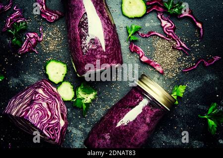 Smoothies disintossicazione sano e utile o succo di cavolo rosso, cetrioli con semi di chia in bottiglie di vetro su uno sfondo grigio, vista dall'alto Foto Stock