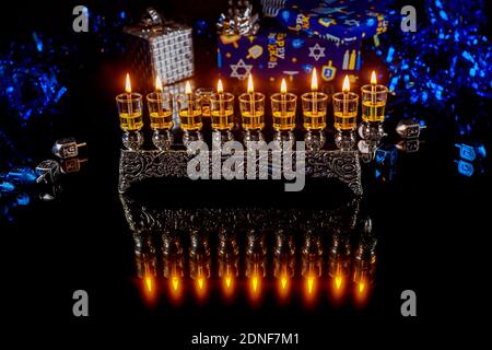 Menorah with burning candles with reflection for Hanukkah jewish holiday. Foto Stock