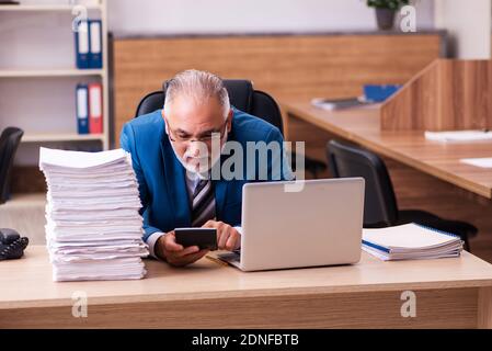 Il vecchio dipendente maschio è insoddisfatto del lavoro eccessivo sul posto di lavoro Foto Stock