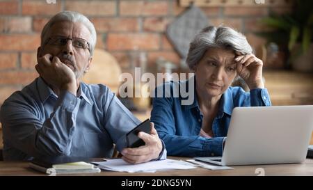 Infelice anziana coppia di anziani che pensa ai problemi finanziari. Foto Stock