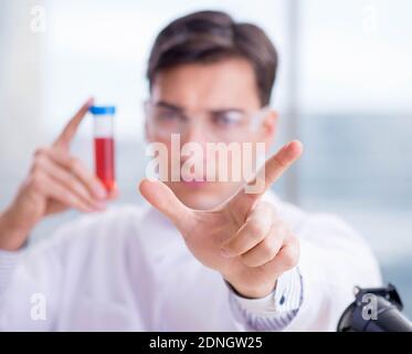 Il medico che controlla i campioni di sangue in laboratorio Foto Stock