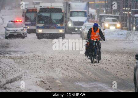 Una vista di un personale di consegna di cibo in bicicletta durante una tempesta invernale. La mattina dopo una potente tempesta invernale ha colpito gli stati nordorientali degli Stati Uniti, una grande tempesta di neve ha colpito la costa orientale degli Stati Uniti durante le prime ore del giovedì, creare ulteriori sfide nel bel mezzo di una pandemia di coronavirus e di una campagna di vaccinazione di massa che si svolge in tutta la regione. La tempesta invernale, che si sposta su New York, in Pennsylvania e in altri stati del nord-est, lascia milioni di persone che si trovano a fronteggiare più di un piede di neve una settimana prima di Natale, interrompendo potenzialmente i test dell'incoronavirus e ritardando le consegne delle festività. Ha anche lasciato più di 60 mi Foto Stock