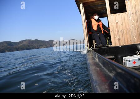 (201218) -- JINZHAI, Dec. 18, 2020 (Xinhua) -- Yu Jiajun drives his boat to make a visit in Jinzhai County of Luan City, east China's Anhui Province, Dec. 16, 2020. Deep in the Xianghongdian Reservoir area in Jinzhai County of Luan City, east China's Anhui Province, there is an isolated island, which used to be home to over 40 poor families. Yu Jiajun, 42, is the only doctor in the village. 'In the past, there was no health station on the island. Villagers had to row a boat for two or three hours to go to the health center in Mabu Township to see the doctor.' Yu said. When Yu Jiajun retu Stock Photo