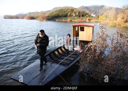 (201218) -- JINZHAI, 18 dicembre 2020 (Xinhua) -- Foto scattata il 16 dicembre 2020 mostra Yu Jiajun che fa una visita alla sua barca nella contea di Jinzhai della città di Luan, provincia di Anhui della Cina orientale. Nel profondo dell'area del bacino idrico di Xianghongdian nella Contea di Jinzhai di Luan City, nella provincia di Anhui, nella Cina orientale, c'è un'isola isolata, che in passato ospita oltre 40 famiglie povere. Yu Jiajun, 42 anni, è l'unico medico del villaggio. 'In passato, non c'era una stazione sanitaria sull'isola. Gli abitanti del villaggio dovevano fare fila per due o tre ore per andare al centro sanitario di Mabu Township per vedere il medico." Yu ha detto. Quando Foto Stock