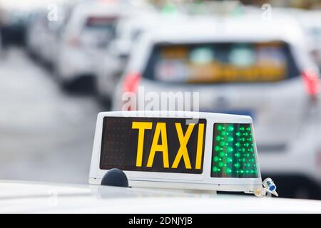 Cartello taxi con veicoli pubblici fuori fuoco. Trasporto urbano Foto Stock