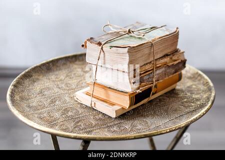 Vecchi libri di 100 anni su antichi closeup tavolo. Storia, conoscenza, nostalgia, concetto di vecchiaia. Stile retrò. Foto Stock