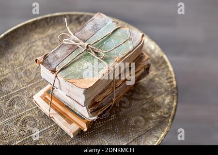 Vecchi libri di 100 anni su antichi closeup tavolo. Storia, conoscenza, nostalgia, concetto di vecchiaia. Stile retrò. Foto Stock