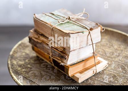 Vecchi libri di 100 anni su antichi closeup tavolo. Storia, conoscenza, nostalgia, concetto di vecchiaia. Stile retrò. Foto Stock
