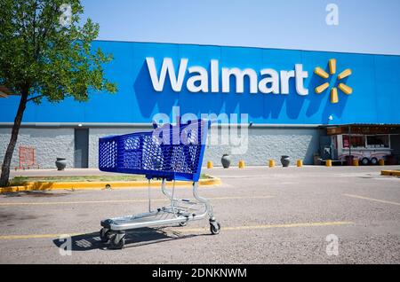 Mendoza, Argentina - Gennaio, 2020: Carrello di shopping su un parcheggio di fronte all'entrata principale del supermercato Walmart all'aperto sulla strada senza peop Foto Stock