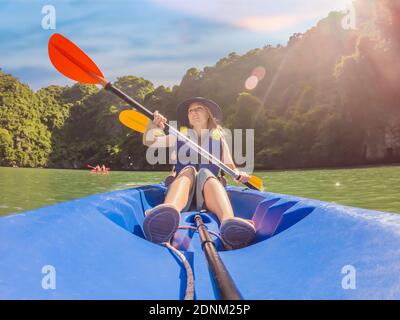 I viaggiatori di mamma, papà e figlio che girano su un kayak nella Baia di ha Long. Vietnam. Viaggio in Asia, emozione di felicità, concetto di vacanza estiva. Viaggiare con Foto Stock