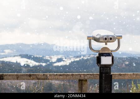 Telescopi turistici guardare in cima alle montagne, primo piano binocoli in metallo sullo sfondo punto panoramico che domina la montagna, monete hipster operated in panoramico Foto Stock